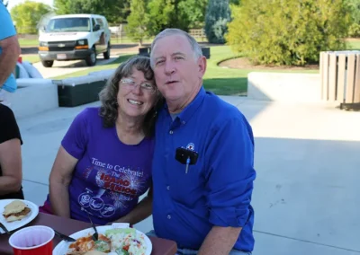 Couple smiling while eating at BBQ event