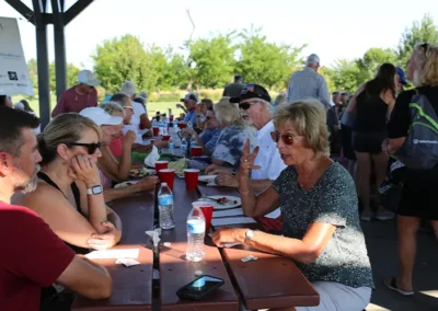 People eating together at outdoor BBQ event