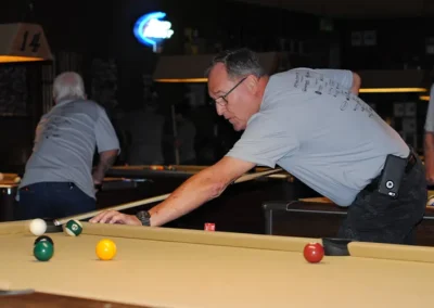Man aiming shot while playing billiards at an indoor pool table game