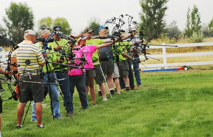 Senior participants competing in archery event outdoors