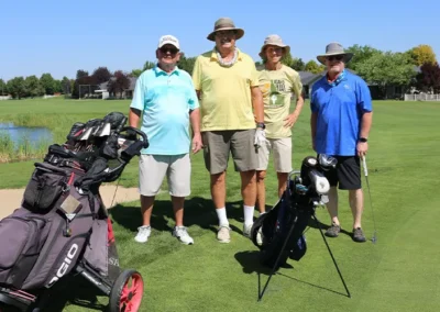 Senior golfers standing on course with clubs and bags