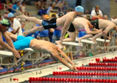 Senior swimmers diving into lanes during competition