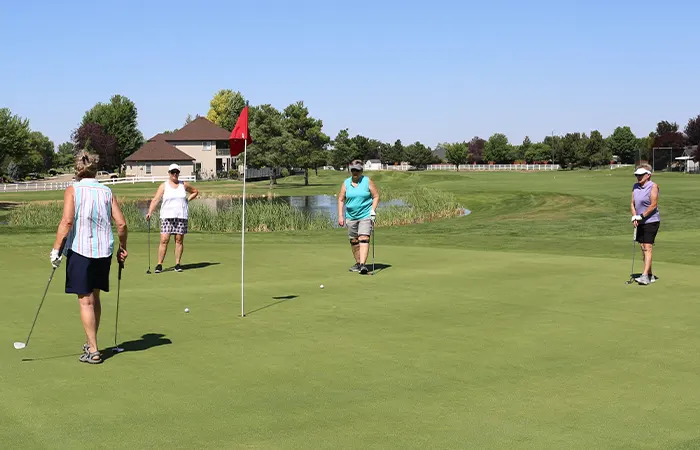 Senior women playing golf on course outdoors