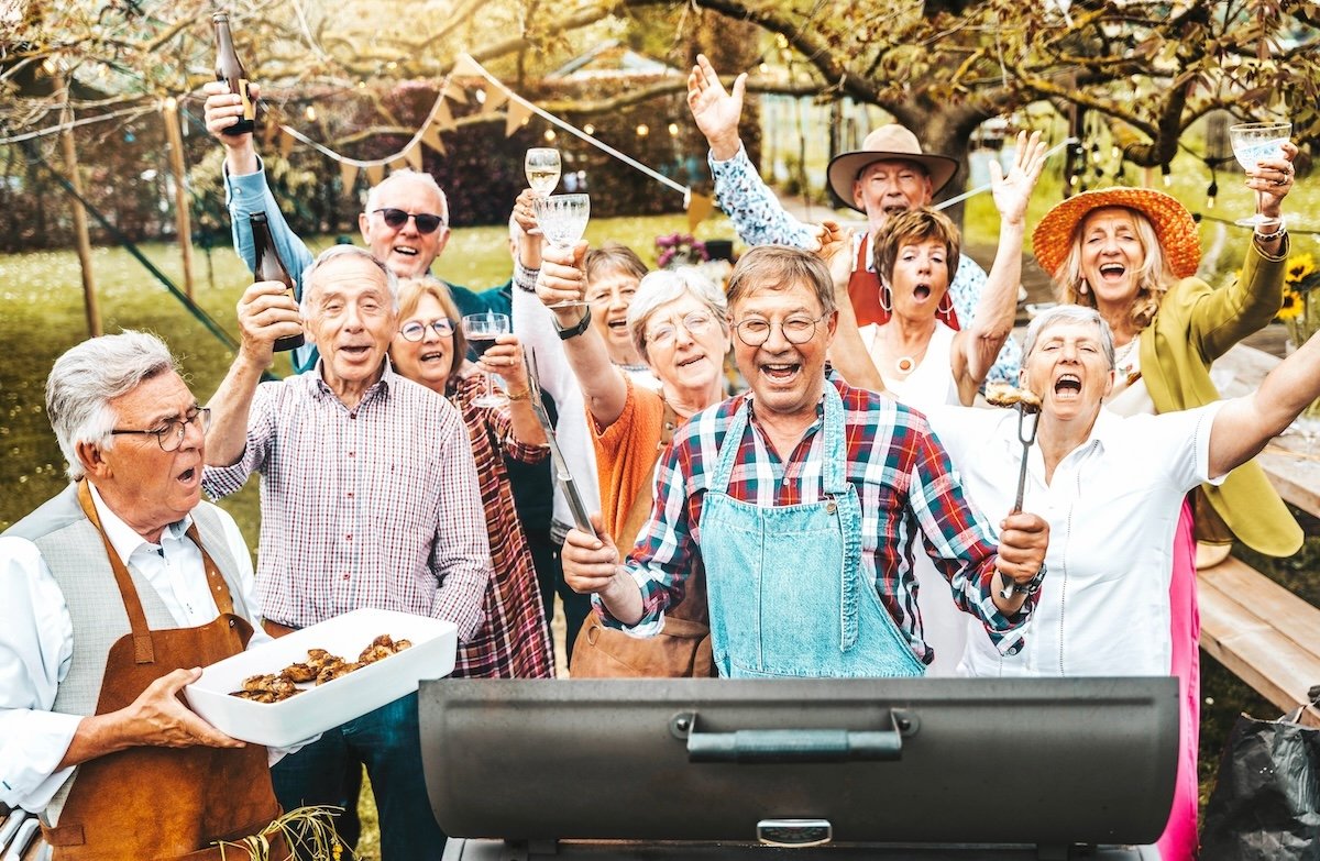 Happy senior group having barbecue dinner party in home backyard - Aged friends celebrating summertime diner break outside - Life style concept with pensioners enjoying time together