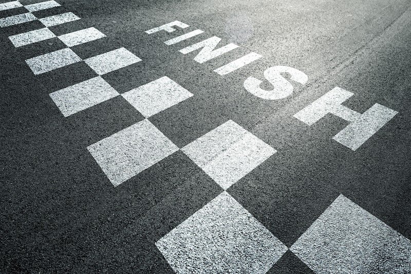 Sunny finish line pattern racing background on the asphalt floor.
